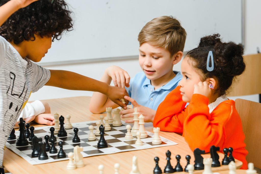 Drei Kinder beim Schachspielen
